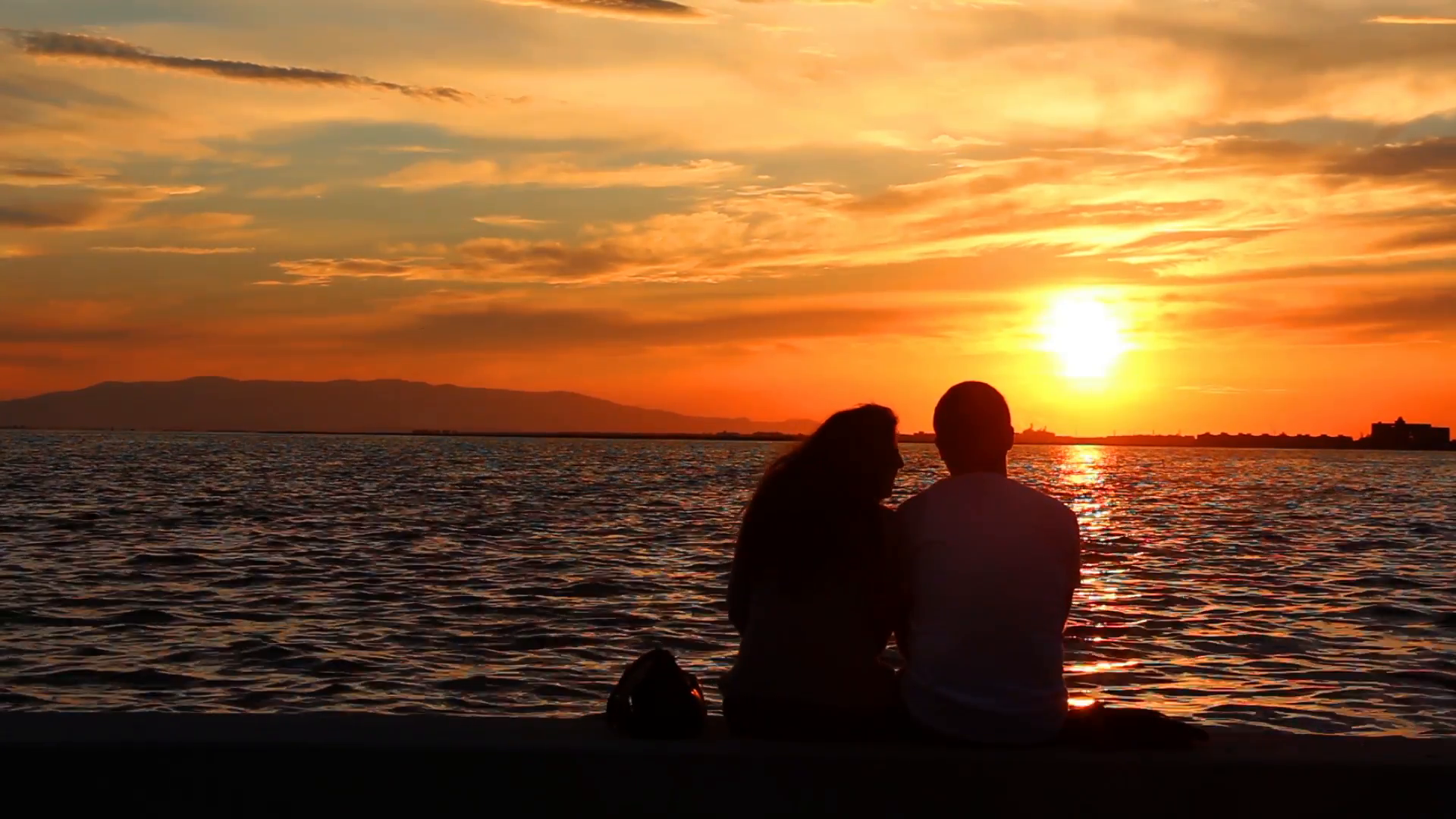 loving-couple-on-the-beach-sitting-sunset_4uuls4t3x__f0000