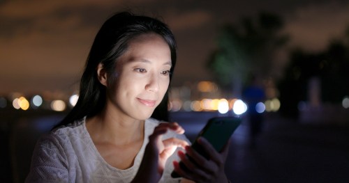 woman-looking-cellphone-city-night-footage-088642575_prevstill